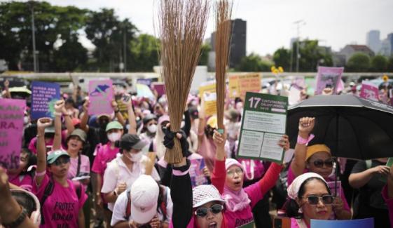 Indonesian women in pink, armed with broomsticks join protests 