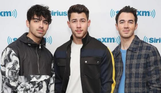 Jonas Brothers surprise crowd with fan’s baby gender reveal live on stage
