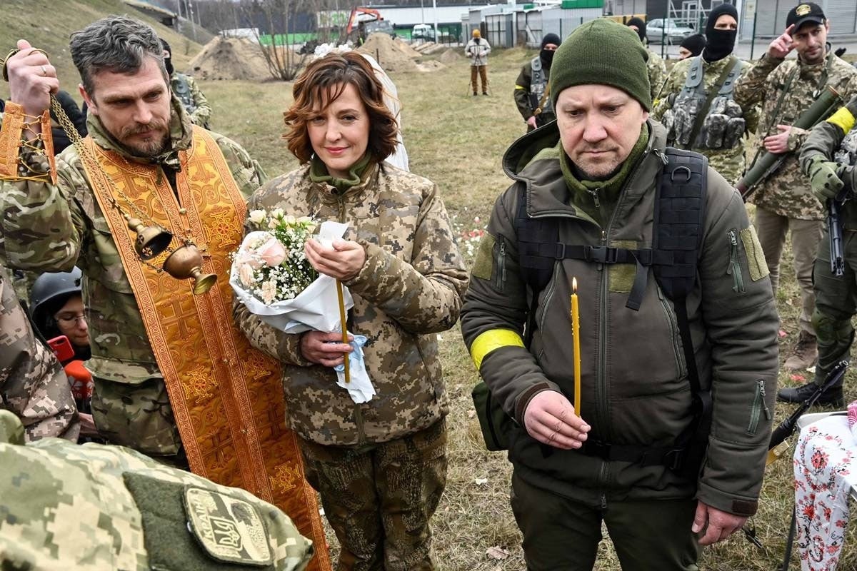 ایک پیاری جوڑی جن کا نام لیسیا اور ویلری ہے ، جو علاقائی دفاع کے ساتھ ہیں، کیف کے قریب شادی کا جشن منا رہے ہیں۔