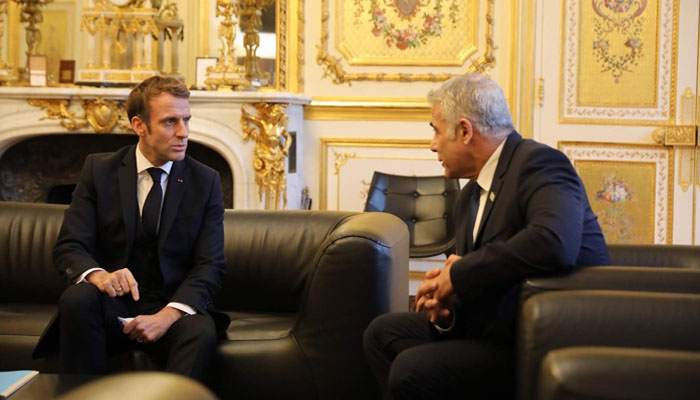 فرانس کے صدر ایمانوئیل میکرون اور اسرائیلی وزیراعظم یائر لاپد گفتگو کر رہے ہیں - فوٹو: فائل
