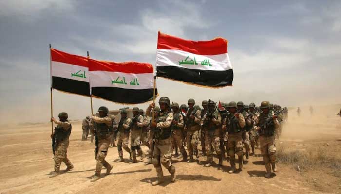 عراقی فوج کا ایک دستہ قومی پرچم اٹھائے مشق میں شریک ہے، فائل فوٹو