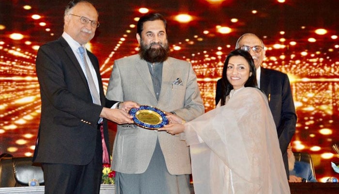 وفاقی وزیر احسن اقبال ڈاکٹر ثمرین حسین کو ایوارڈ دیتے ہوئے۔