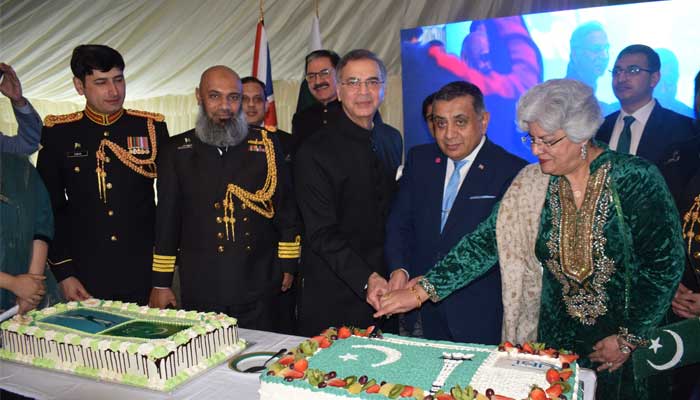 یوم پاکستان کی تقریب کے موقع پر پاکستانی ہائی کمشنر اور دیگر حکام کیک کاٹ رہے ہیں۔