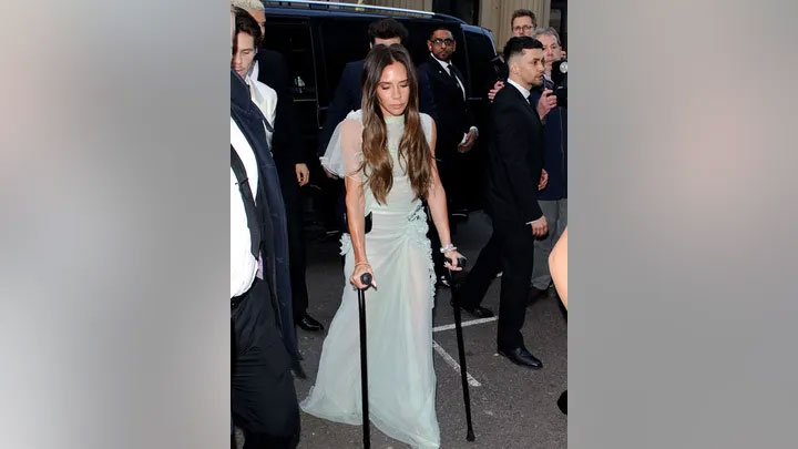 Victoria Beckham arrives at her 50th birthday party on crutches 