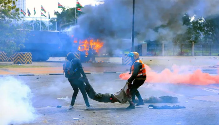 کینیا میں مظاہرے میں بےہوش شخص کو ریسکیو اہلکار اٹھا کر لے جارہے ہیں(تصویر سوشل میڈیا)۔