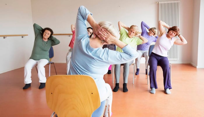 Chair yoga helps desk-bound office people to stay healthy and active while sitting on chair