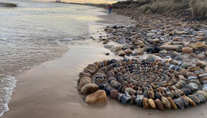 Mysterious artist wows beachgoers with stunning colorful stone sculpture