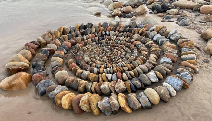 Mysterious artist wows beachgoers with stunning colorful stone sculpture