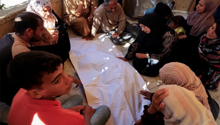 ایک کمسن شہید کی لاش کے گرد لواحقین غمزدہ بیٹھے ہیں—تصویر سوشل میڈیا