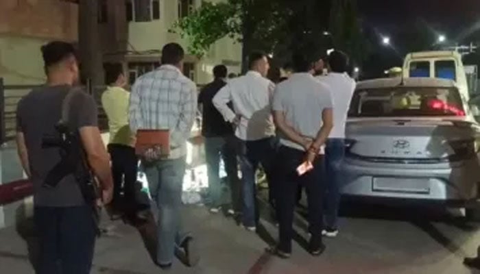 جس کار سے لاشیں ملی اسکے گرد پولیس اور تفتیش کار موجود ہیں(تصویر سوشل میڈیا)۔